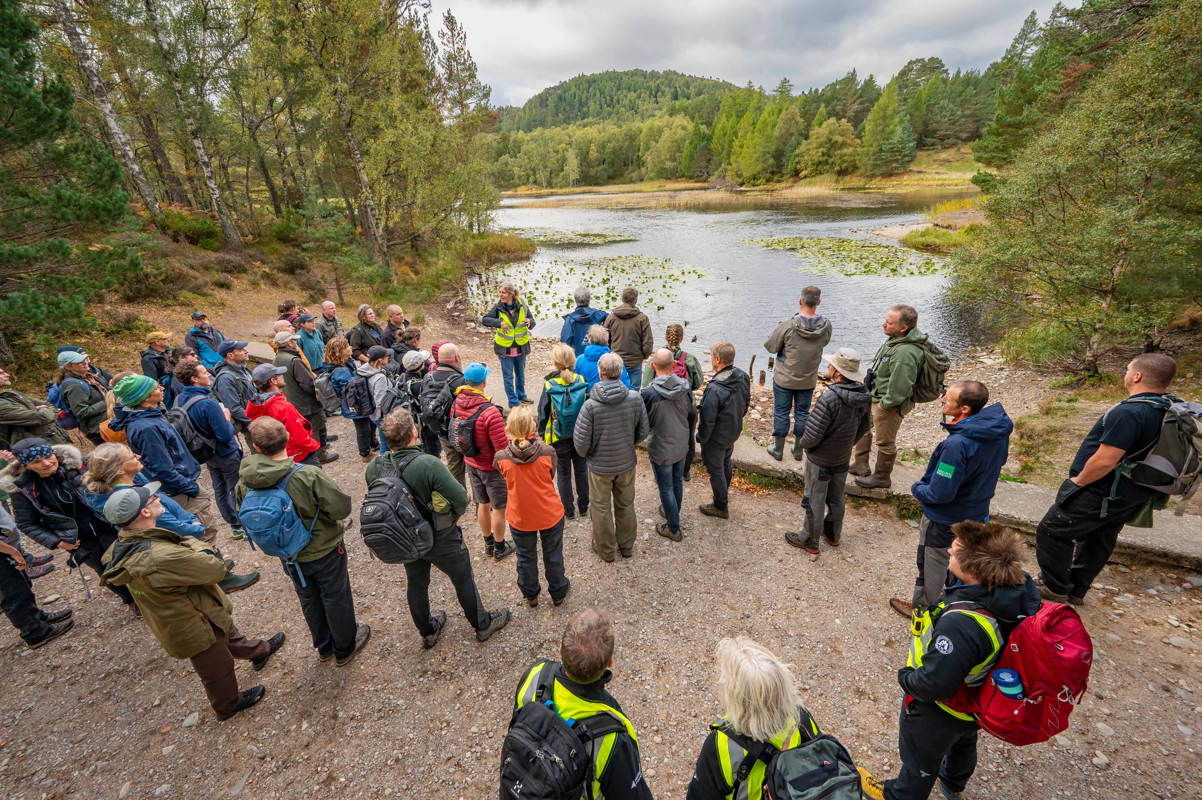 Delegates standing by a loch