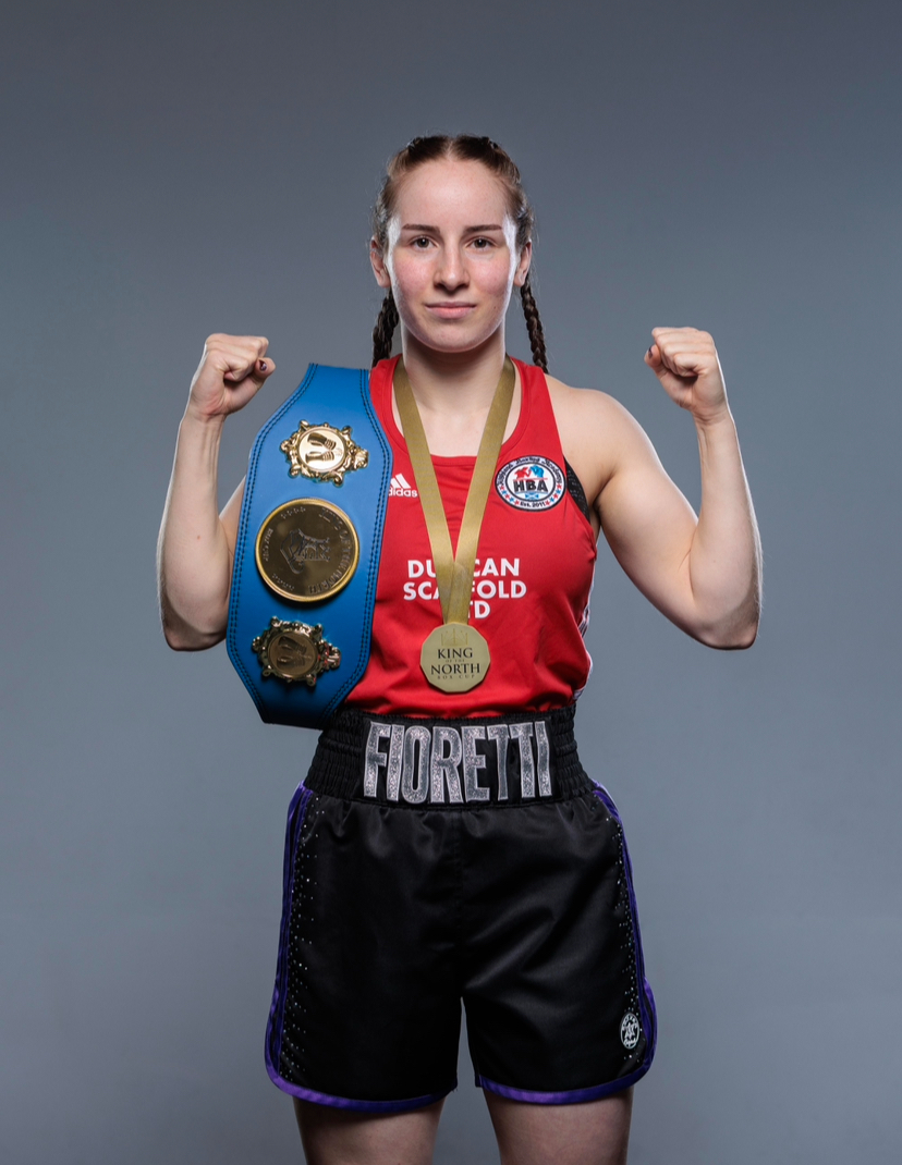 Isabella Fioretti, a sports coaching and development student at UHI Inverness, in boxing attire carrying medals