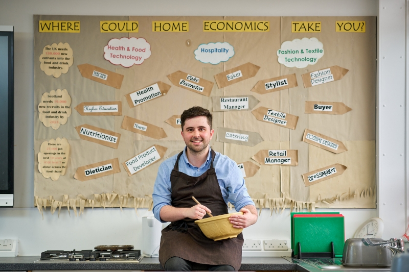 Kyle MacLennan mixing ingredients in a kitchen classroom.